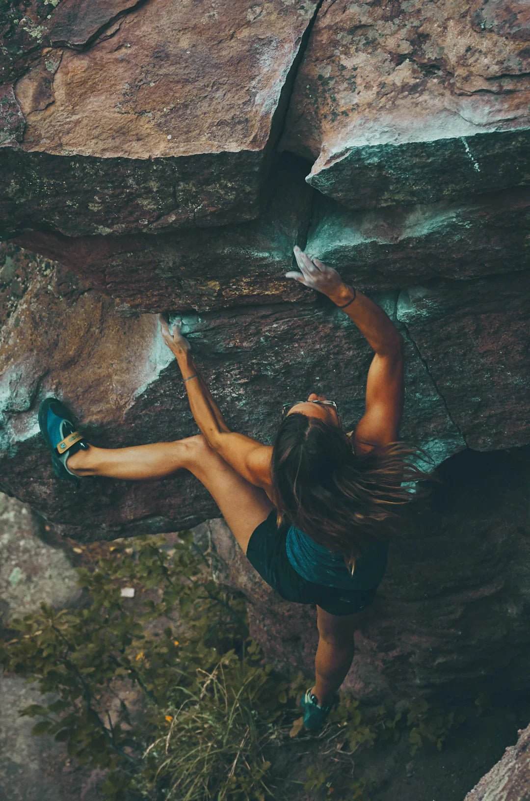 Woman rock climbing outdoors demonstrating strength and endurance related to long-term sports nutrition strategies