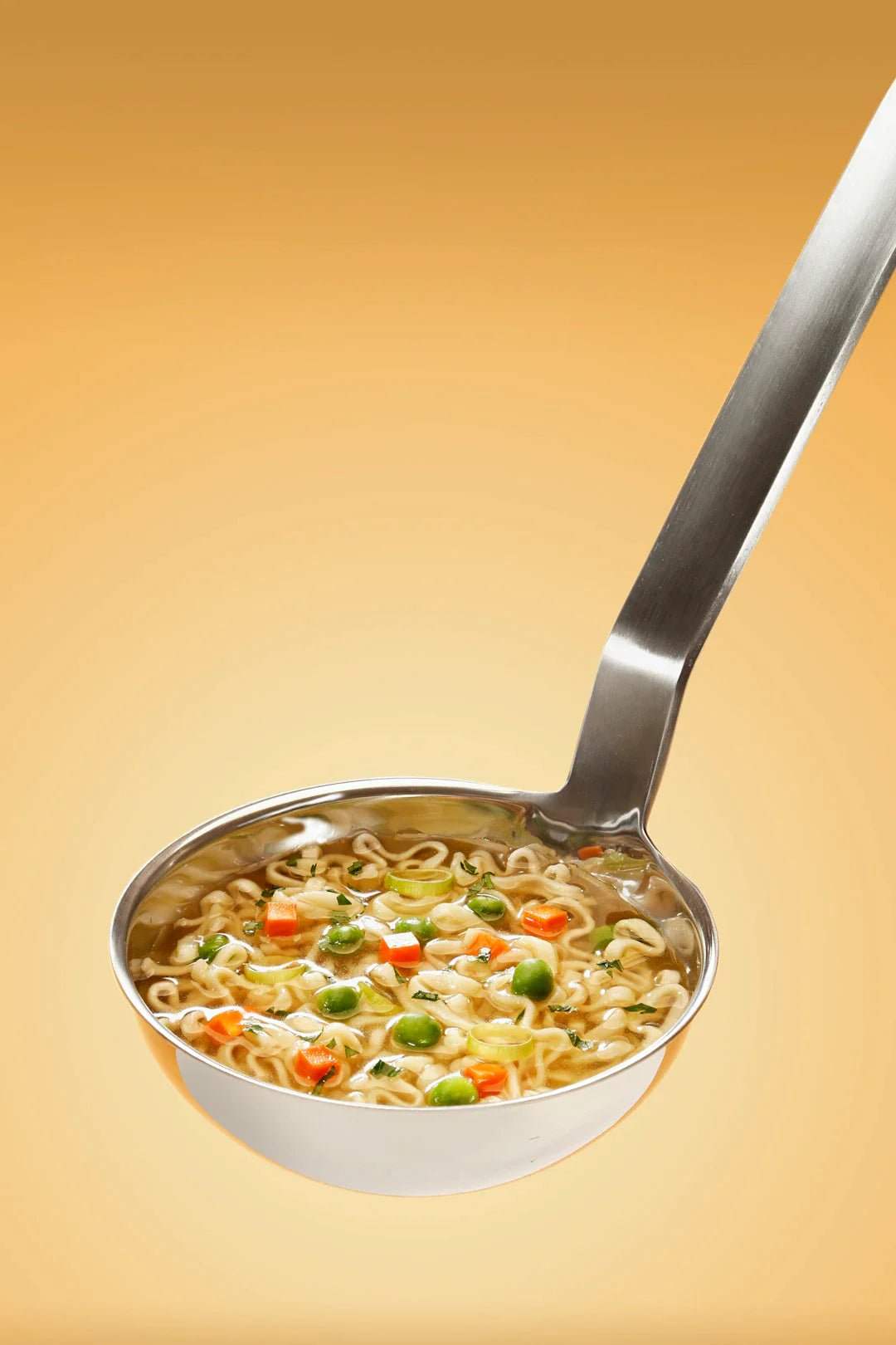 Ladle filled with nutritious vegetable noodle soup for meal prep for athletes