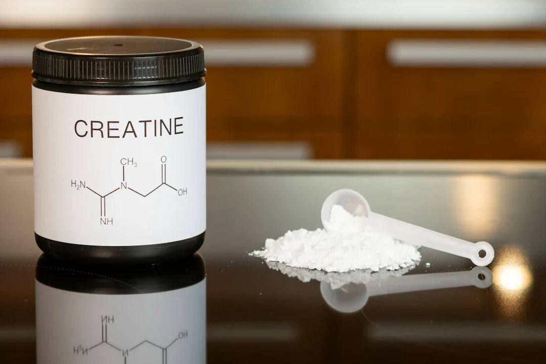 Creatine supplement container with chemical structure and white powder scoop, sports nutrition product.